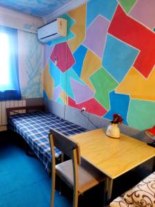 ein Zimmer mit einem Tisch und einer farbenfrohen Wand in der Unterkunft Asine Yerevan in Yerevan