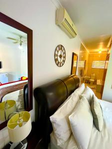 Swane’s guesthouse. في روستنبرج: غرفة نوم بها سرير وساعة على الحائط +22 صورة