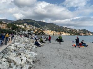 un grupo de personas en una playa cerca del agua en Rapallo Minimal House, en Rapallo