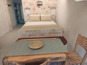 a room with two beds and a table with a hat on it at Apanemo Beach House Agios Nikolaos Kimolos in Kimolos