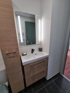 uma casa de banho com um lavatório e um espelho em Stella em Arès