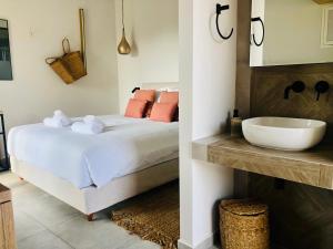 a bedroom with a white bed and a sink at Princess Hotel in Lassi