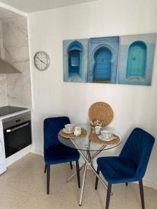 a kitchen with a table and chairs and a clock at Belissimo Apartment 2 Bedrooms with patio BY NAMASTE ELITE in Torremolinos