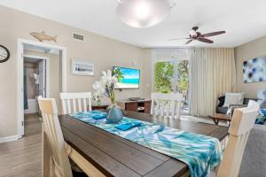 een eetkamer en een woonkamer met een tafel en stoelen bij 5 Star Resort 2BR 2 BATH King Suite Shuttle Pools Across from Beach in Destin