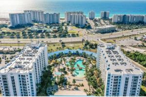 an aerial view of a resort with a pool and the ocean at 5 Star Resort 2BR 2 BATH King Suite Shuttle Pools Across from Beach in Destin