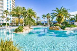 5 Star Resort 2BR 2 BATH King Suite Shuttle Pools Across from Beach في ديستين: مسبح في منتجع فيه نخل