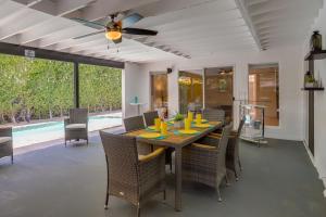 a dining room with a table with chairs and a ceiling fan at Sunny Palm Springs Home with Private Pool and Patio! in Palm Springs