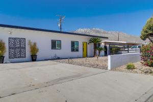 a white house with a yellow door at Sunny Palm Springs Home with Private Pool and Patio! in Palm Springs