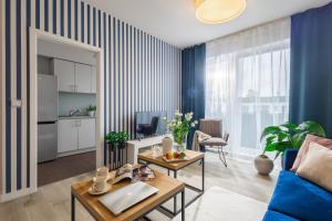 a living room with a blue and white striped wall at Apartment Dąbrowskiego by The Railway Station Wroclaw in Wrocław