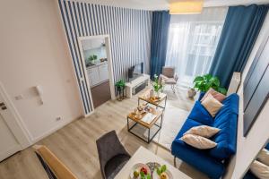 a living room with a blue couch and a table at Apartment Dąbrowskiego by The Railway Station Wroclaw - MAMY WOLNE POKOJE ! in Wrocław