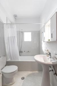 a white bathroom with a toilet and a sink at Nick & Debbie's two-storey apartment in Mélanes