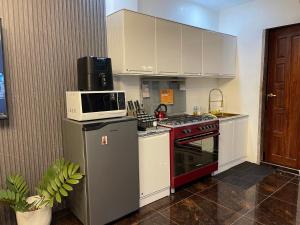 a kitchen with a microwave on top of a stove at Vitasolo Hometel & Suite in Tagum