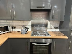 a kitchen with a stove top oven and a microwave at Bigg Market Apartments in Newcastle upon Tyne