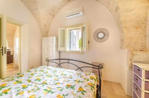 una camera con un letto e un piumone floreale di Casale dolina verde a Ostuni