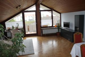 a large living room with large windows and a television at Blick ins Grüne in Überlingen