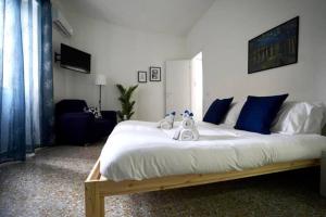 a bedroom with a large white bed with blue pillows at Cinecittà Luxury Flat Metro A in Rome