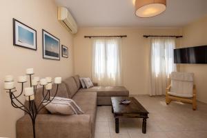 sala de estar con sofá y mesa en White Holidays Project Ag. Sostis, en Agios Sostis