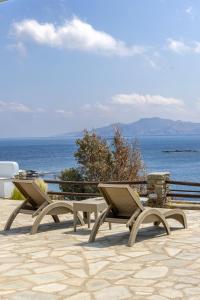 2 stoelen op een patio met uitzicht op de oceaan bij White Holidays Project Ag. Sostis in Agios Sostis