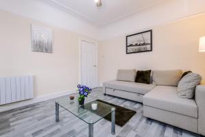 a living room with a couch and a glass table at Beautiful Townhouse Free Parking - Near City and Beach with Fast W-FI in Wallasey