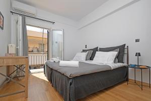 - une chambre avec un grand lit et une fenêtre dans l'établissement Avenue Apartment Corfu Town, à Ágios Rókkos