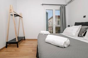 - une chambre avec un lit et des serviettes blanches dans l'établissement Avenue Apartment Corfu Town, à Ágios Rókkos