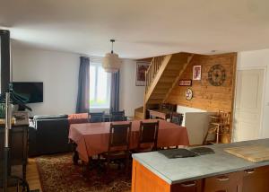 的住宿－Les Gîtes du Manoir de Keryvon，厨房以及带桌子和楼梯的客厅。