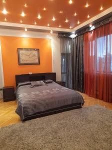 リヴィウにあるVilla ILonaのオレンジ色の壁のベッドルーム1室(キングサイズベッド1台付)