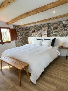 1 dormitorio con cama grande y mesa de madera en Can Jan Vives en Vidreres