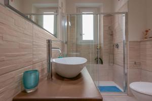 a bathroom with a bowl sink and a shower at Insula b&b in Cagliari