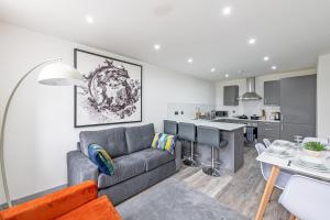 ein Wohnzimmer mit einem Sofa und einer Küche in der Unterkunft Charles House Serviced Apartments in Preston
