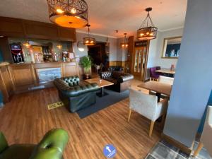 a living room with a couch and a table and chairs at The Calder House Hotel in Seascale