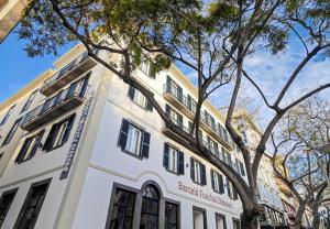 um edifício com uma árvore em frente em Barceló Funchal Oldtown no Funchal