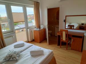 a bedroom with a bed and a desk and a mirror at Letnia willa z sauną in Darłowo