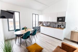 Magnifique Duplex 2ch / 2 sdb في مارسيليا: مطبخ وغرفة طعام مع طاولة وكراسي