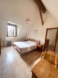 een grote slaapkamer met een bed en een tafel bij Gîte Fuchsia in Carlux