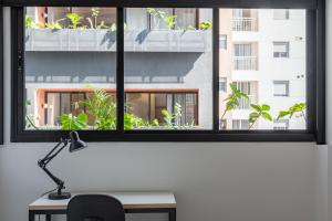 a window with a view of a building with plants at Tabas - Ed. Magdalena Laura - Vila Buarque in Sao Paulo