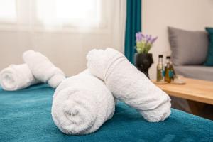 a white towel animal laying on a bed at Artzy petit apartment close to the center in Heraklio Town +54 photos
