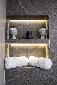 a shelf with two towels and two toilets in a bathroom at Artzy petit apartment close to the center in Heraklio Town