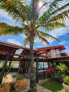 a palm tree in front of a building at Toya Hotel in Ilha Comprida