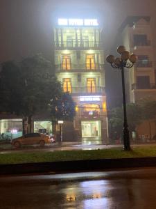 a building on a foggy street at night with a car at Kim Tuyen Hotel in Ninh Binh