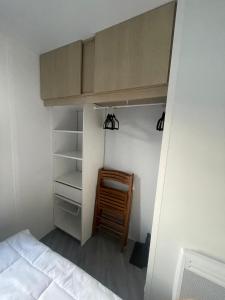 a bedroom with a bunk bed and a wooden chair at - Mobilhome Camping Les Charmettes - Fun pass non inclus - in Les Mathes