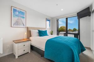 a bedroom with a bed and a large window at Barbadoes Beauty - Christchurch Holiday Apartment in Christchurch