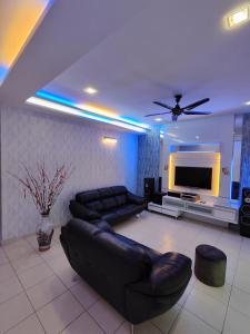a living room with a couch and a flat screen tv at Ipoh Premium Cozy Relax Home in Ipoh