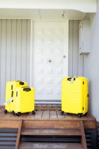 two yellow suitcases sitting on a wooden deck at Beachside Getaway Bay Views North Shore VIC Sleeps 12 Free Wifi in North Shore