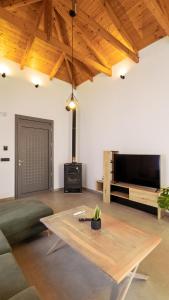 a living room with a coffee table and a flat screen tv at Casa Dionysia - New Lux 2Br with Jacuzzi near Maleme Beach in Maleme