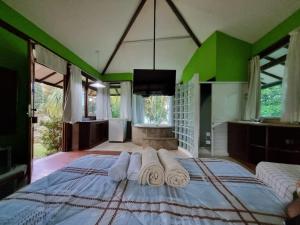 um quarto com uma cama grande e toalhas em Chalés Pico do Caledônia em Nova Friburgo