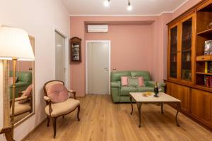 uma sala de estar com um sofá verde e uma mesa em BnButler - Principe Eugenio - Casa Corsini, un Angolo Retrò em Milão