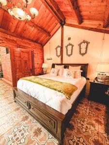 Un dormitorio con una cama grande en una habitación con techos de madera. en Casa Morasan Hotel-Boutique, en Quetzaltenango