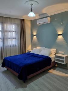 a bedroom with a bed with a blue comforter at Kusadasi Sezgins Boutique Rooms in Kusadası