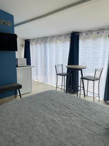 una habitación con sillas y una mesa en una habitación con cortinas azules en Au Sabluline chambres d'hôtes gîtes, en Draguignan